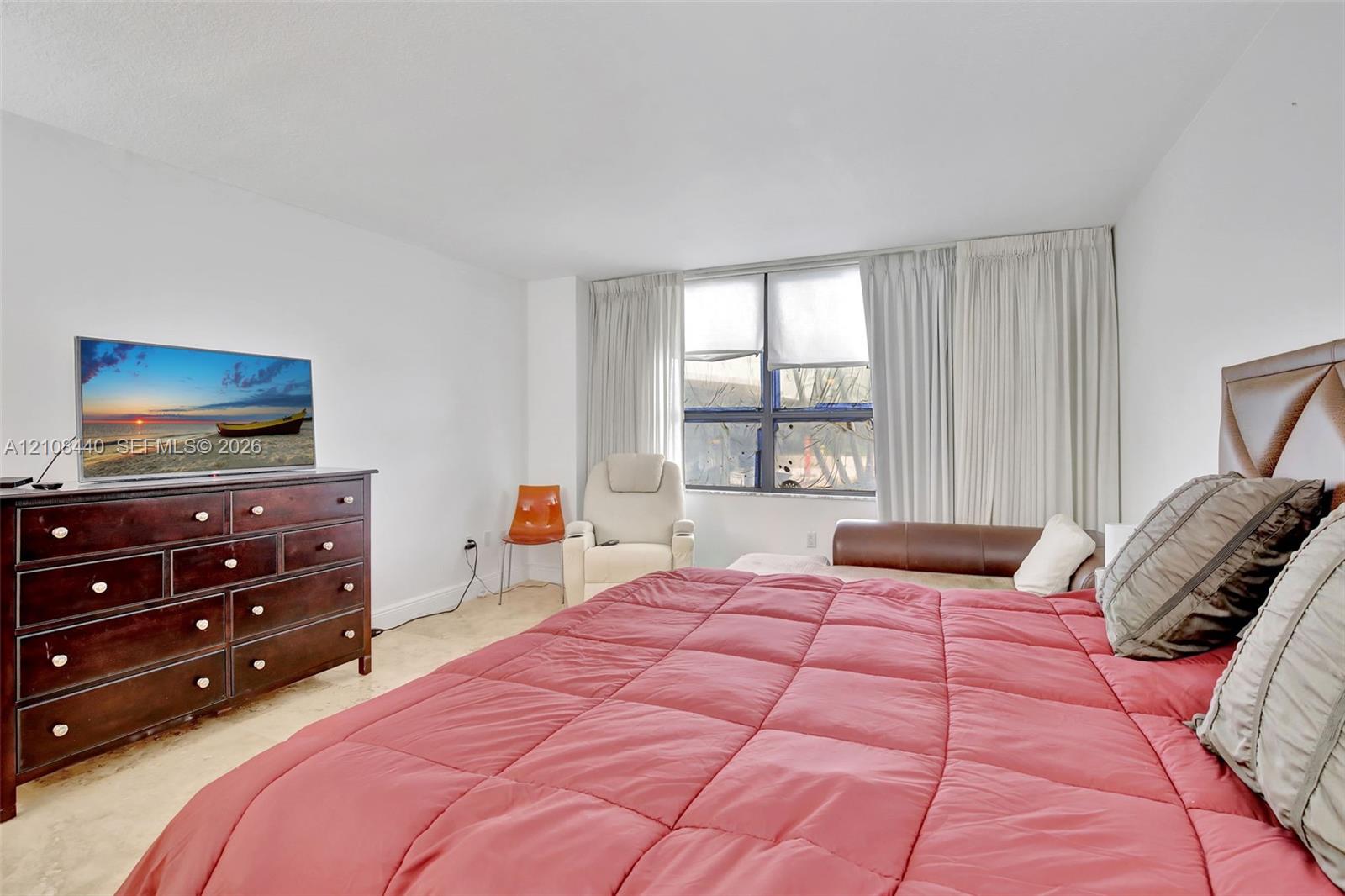 Spacious room featuring large windows, neutral wall finishes, and polished hard-surface flooring