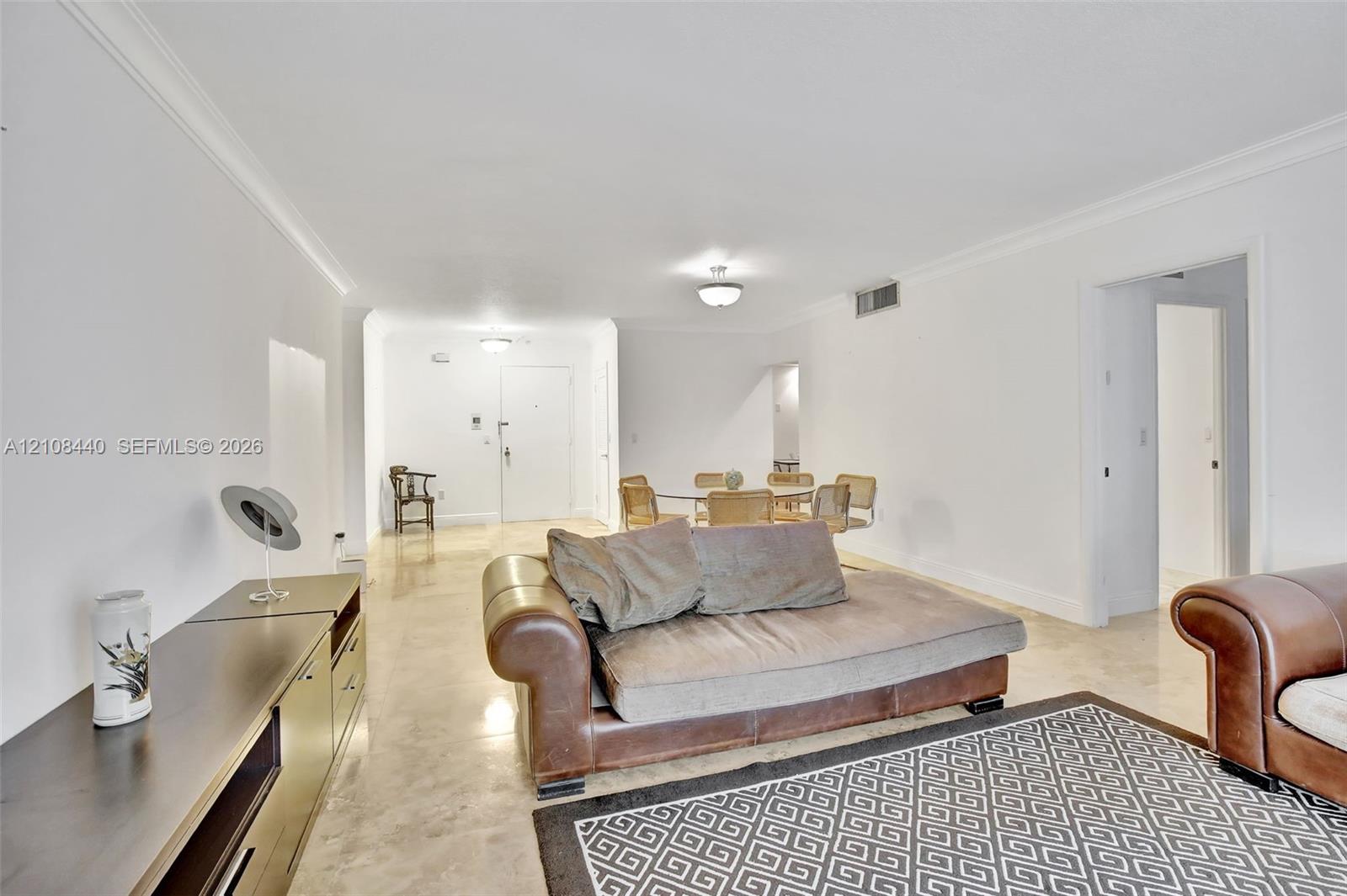 Open-concept interior featuring smooth-finish tile flooring, recessed crown molding, and neutral wall tones Open-concept interior featuring smooth-finish tile flooring, recessed crown molding, and neutral wall tones