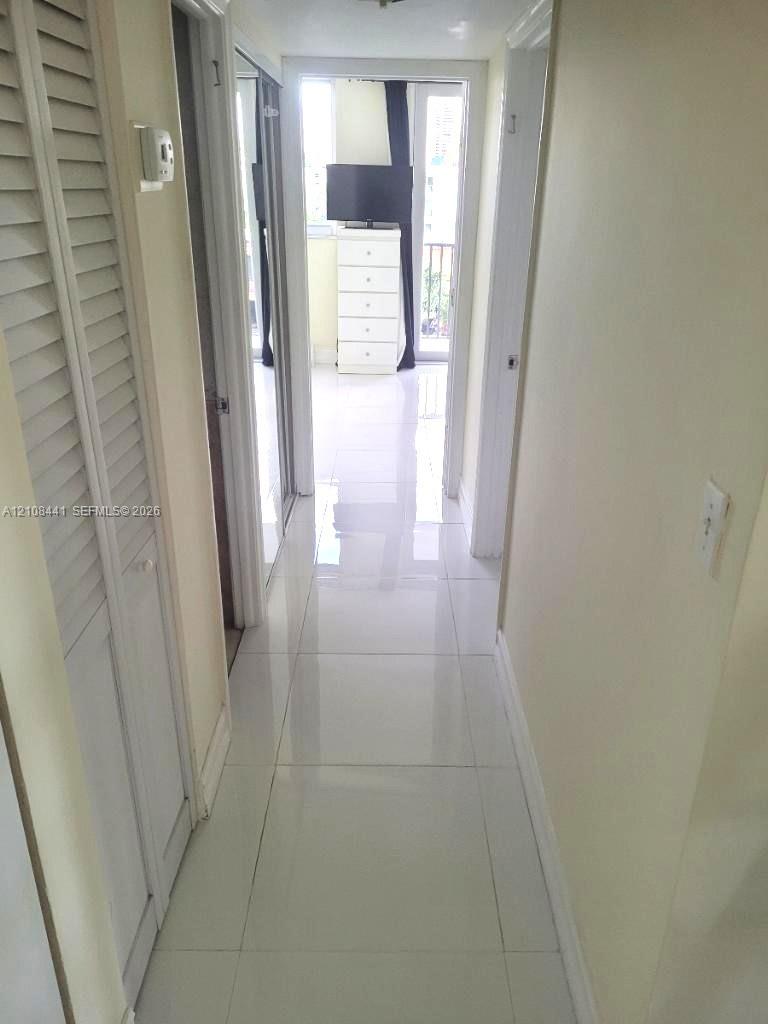 Large-format porcelain tile flooring and louvered bi-fold closet doors