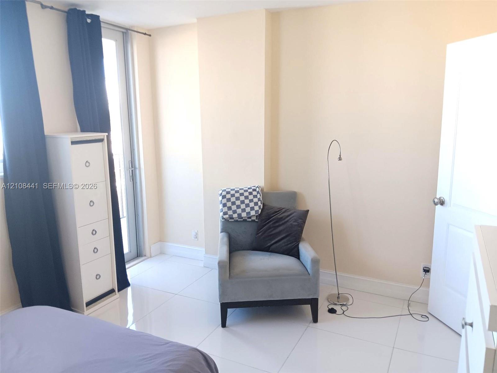 Bright room featuring high-gloss tile flooring and a glass-paned door providing exterior access