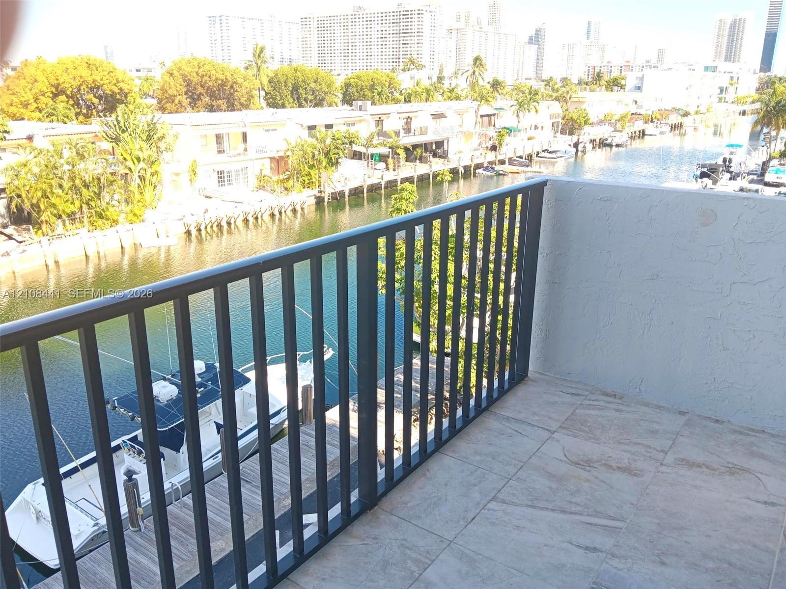 Private balcony featuring tile flooring and metal railing, overlooking the canal and waterfront area
