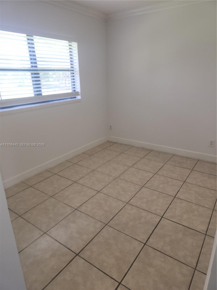 Neutral-toned ceramic tile flooring, crisp white interior paint, and a multi-pane window featuring installed horizontal blinds Neutral-toned ceramic tile flooring, crisp white interior paint, and a multi-pane window featuring installed horizontal blinds