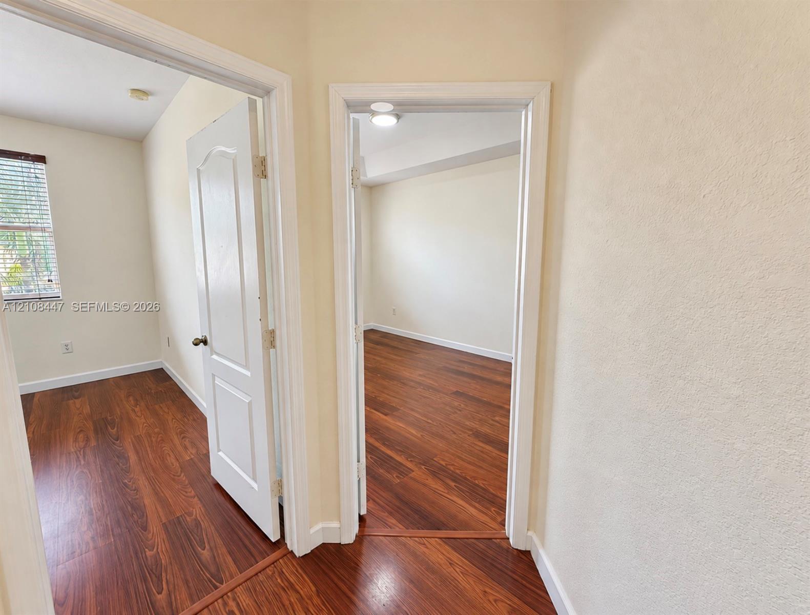 Wood-finish flooring, white paneled interior doors, and neutral wall tones