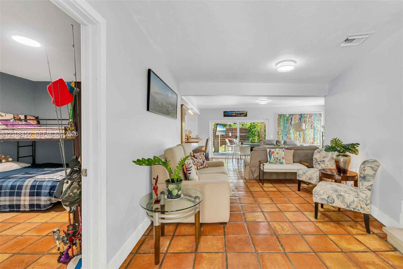 Terra-cotta tile flooring throughout and sliding glass doors leading to the outdoors