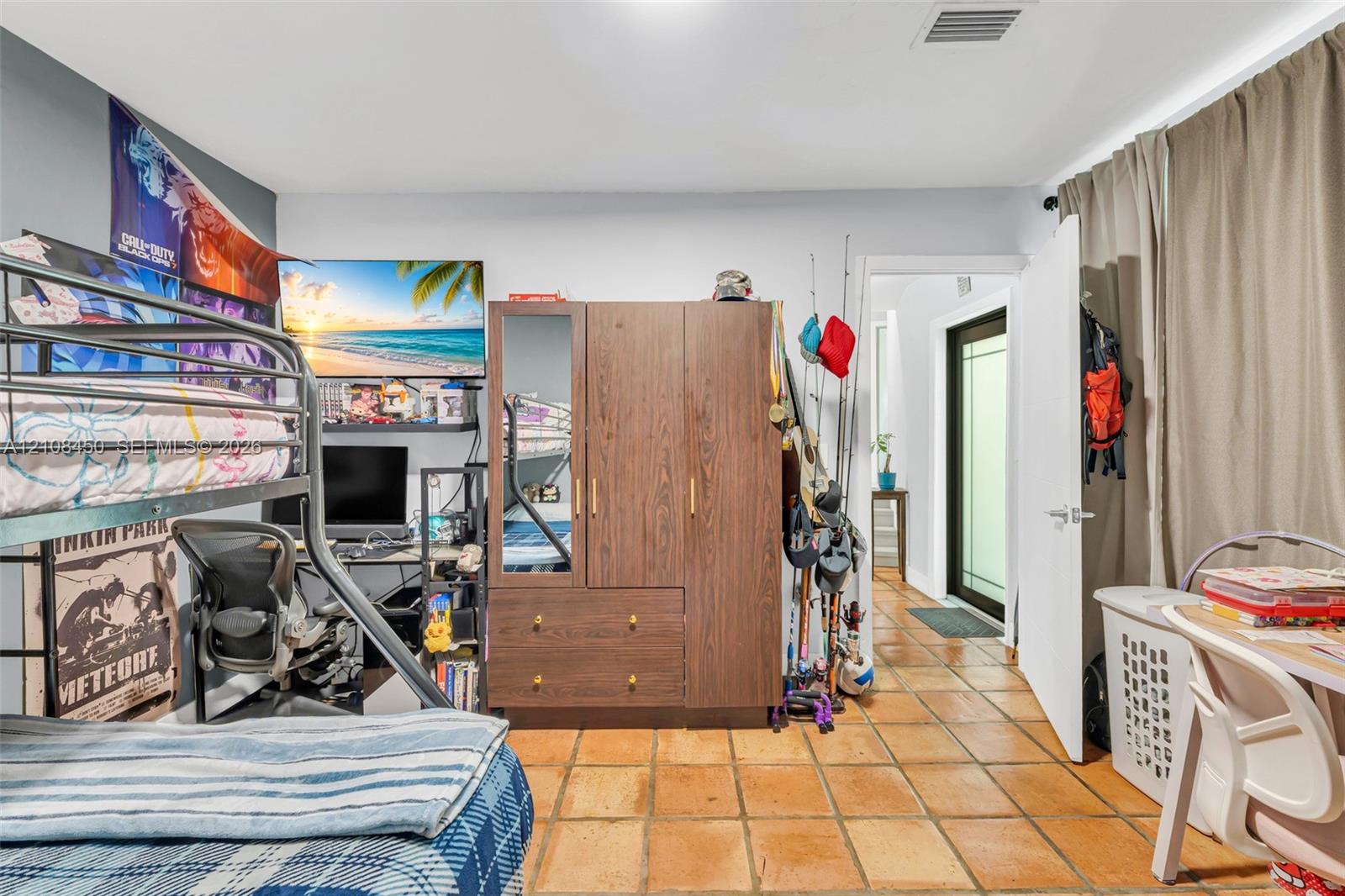 Room featuring terracotta-style tile flooring, neutral wall paint, and an interior door with a glass pane