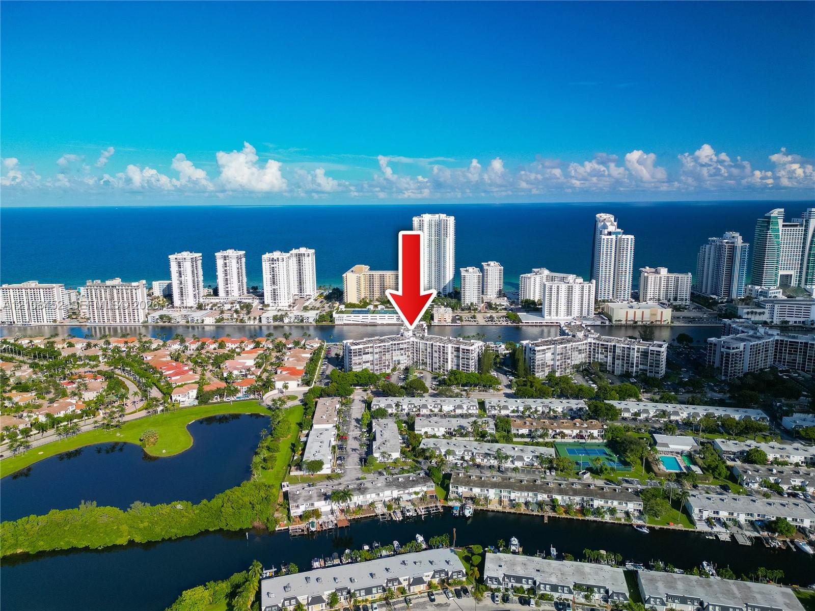 Aerial perspective of waterfront residential complex featuring multiple mid-rise buildings, canal-front positioning, and proximity to the coastline