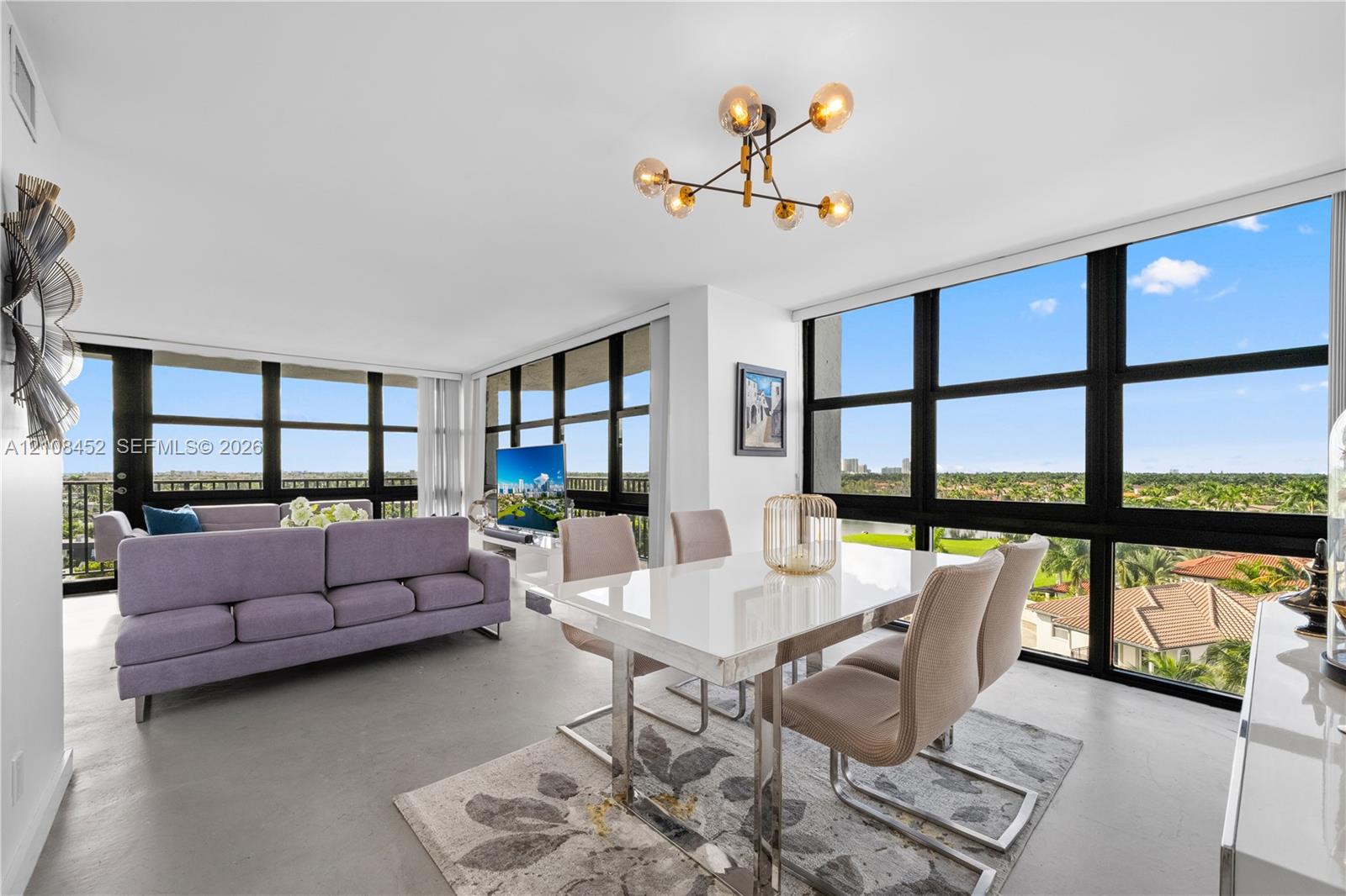 Floor-to-ceiling windows with black framing, exposed-bulb geometric chandelier, and polished concrete flooring