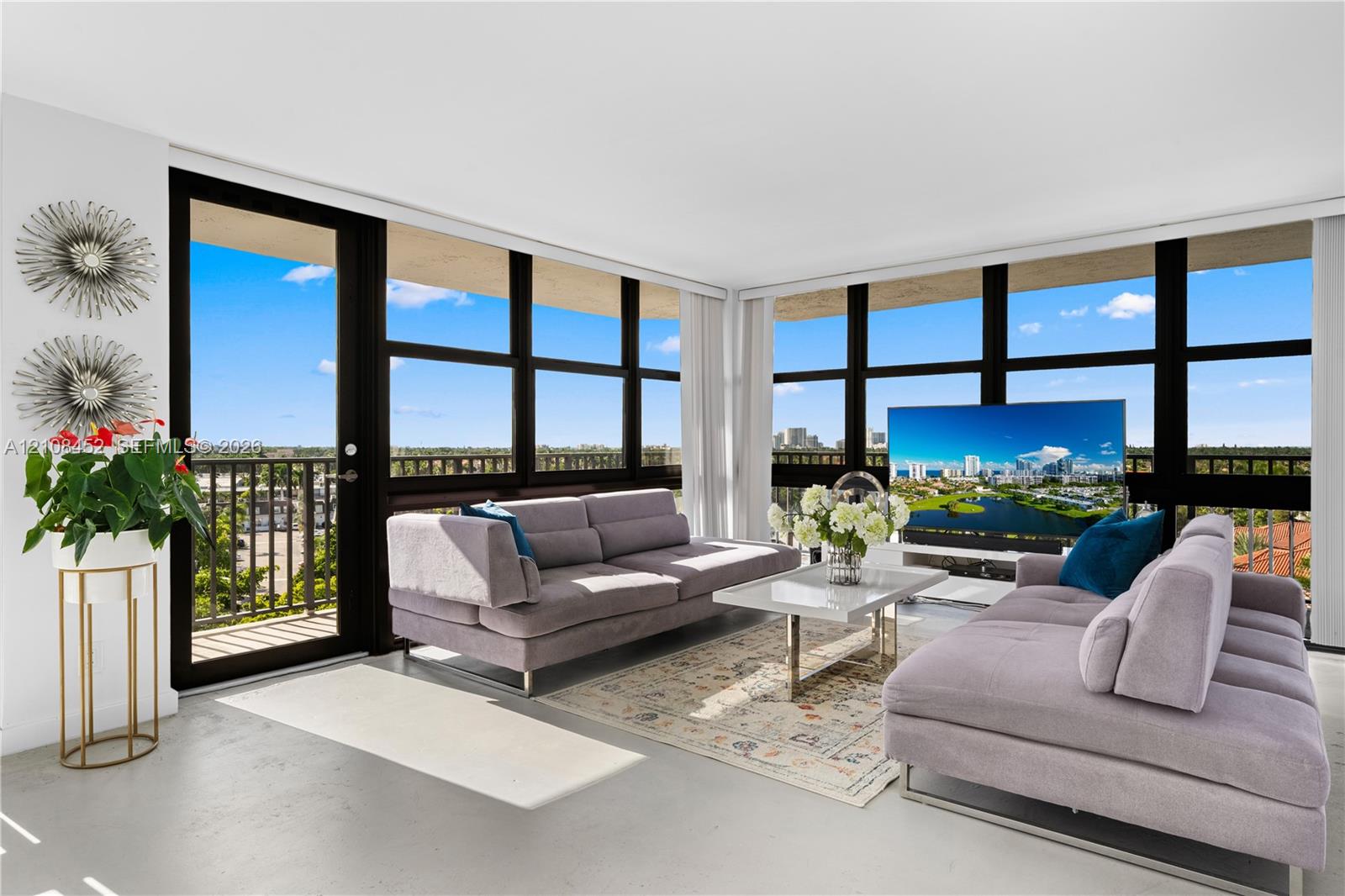 Floor-to-ceiling windows with black framing, integrated balcony access, and neutral polished concrete flooring