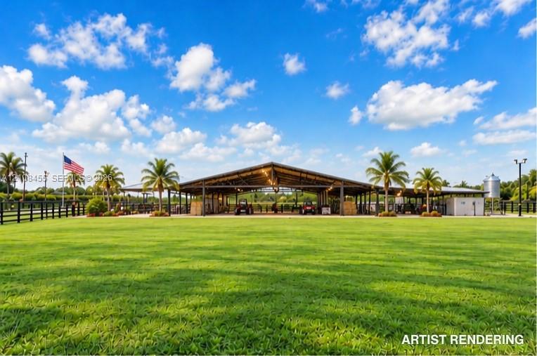 Open-air barn facility featuring a metal roof structure, expansive grass grounds, post-and-rail fencing, and mature palm trees