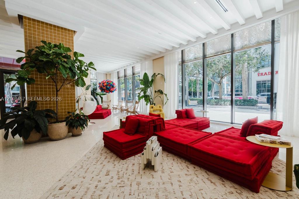 Floor-to-ceiling glass windows, ribbed ceiling detailing, tile-accented structural column, and polished stone flooring