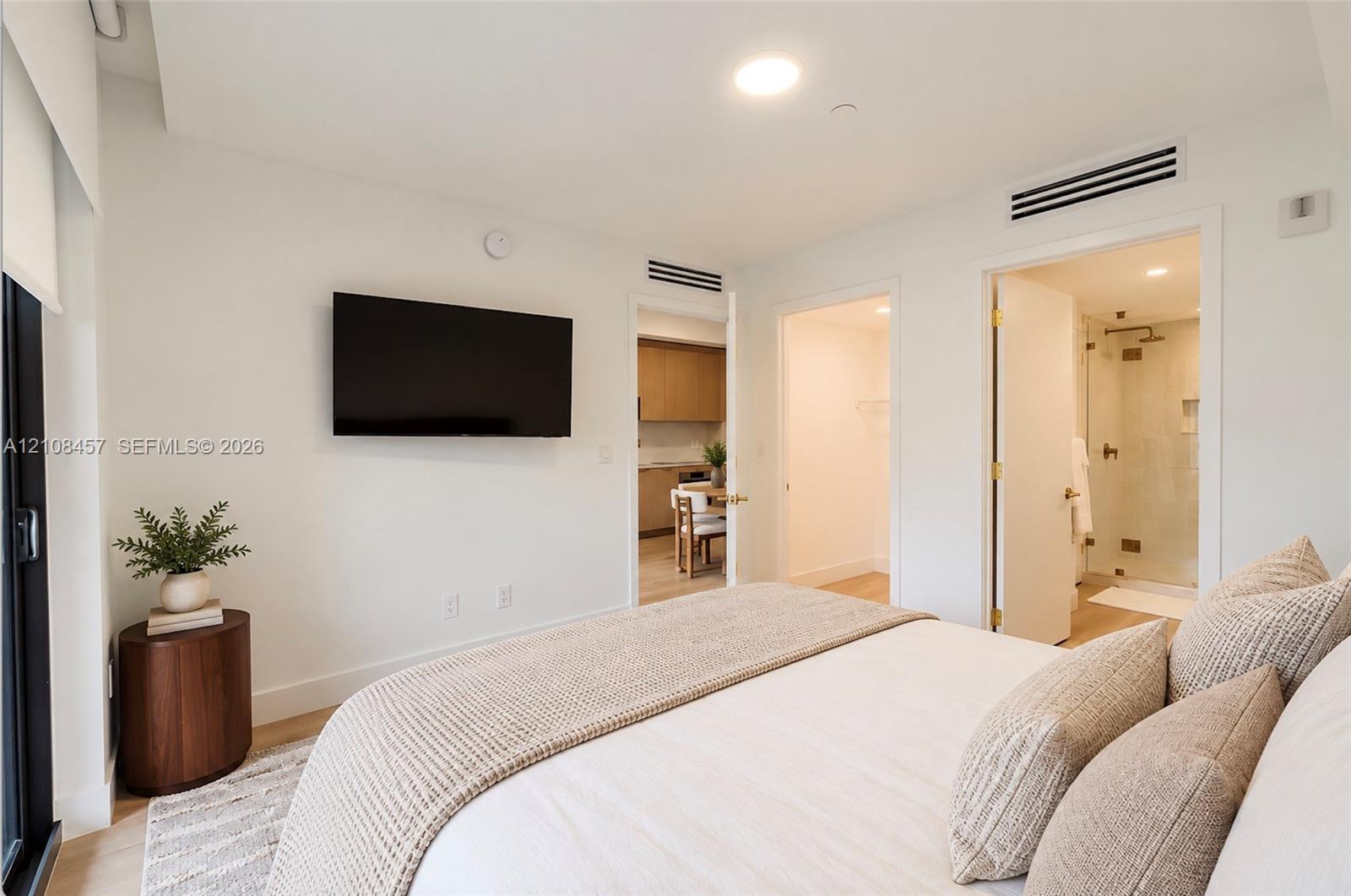Recessed ceiling lighting, light-toned wood-finish flooring, and minimalist white interior wall finish