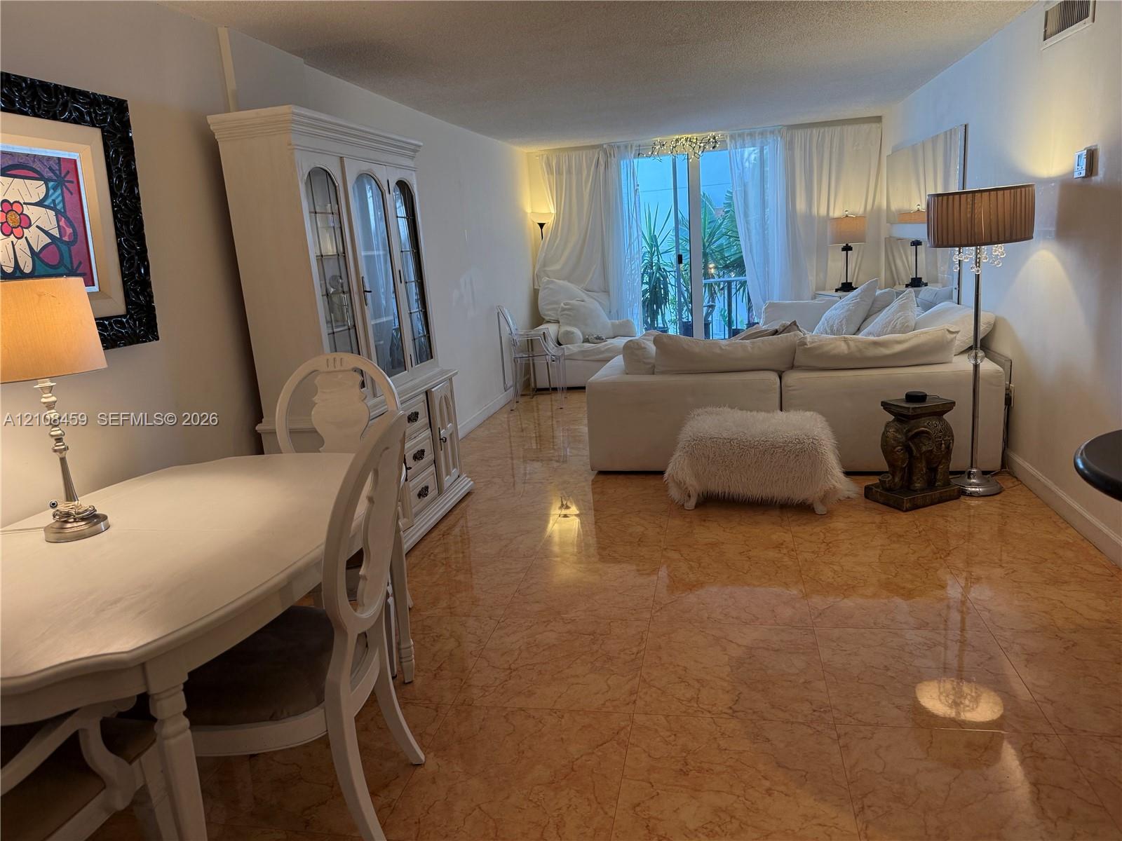 Polished stone flooring, sliding glass door with exterior balcony access, and recessed ceiling lighting Polished stone flooring, sliding glass door with exterior balcony access, and recessed ceiling lighting