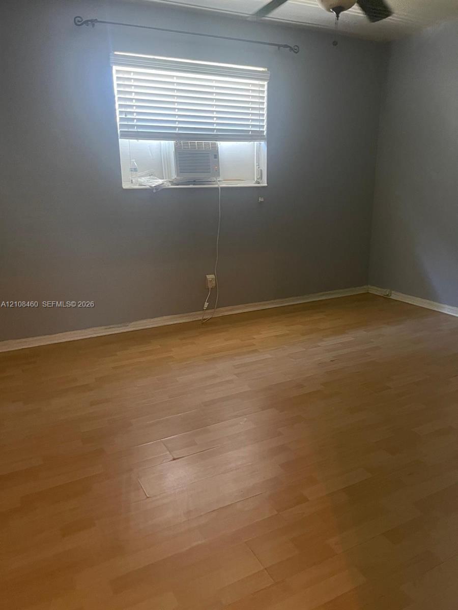 Wood-finish flooring, neutral wall tones, window with integrated blinds, and ceiling fan fixture Wood-finish flooring, neutral wall tones, window with integrated blinds, and ceiling fan fixture