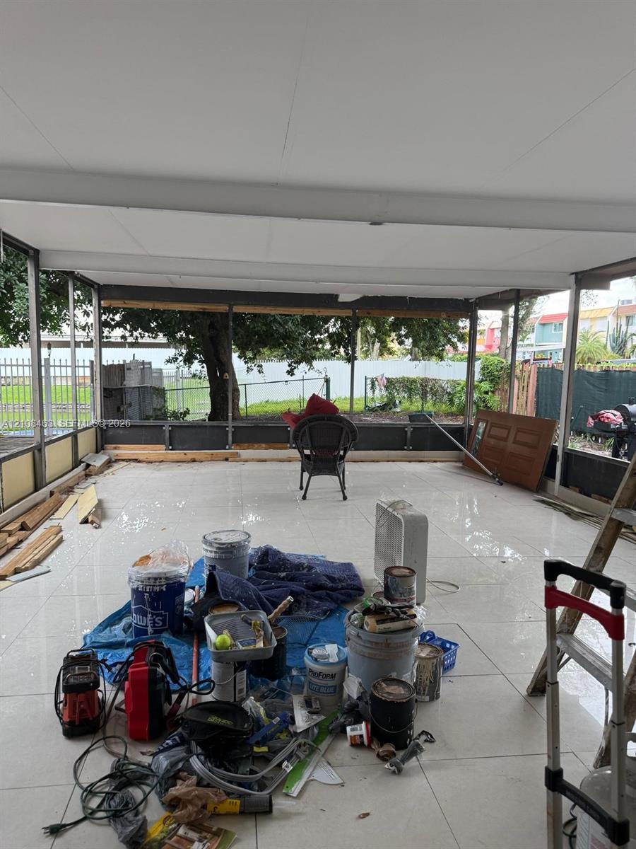 Screened-in patio featuring polished tile flooring, a solid ceiling, and metal framing