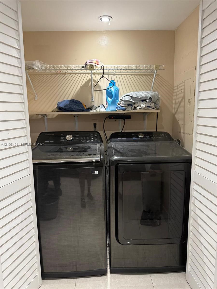 Laundry closet featuring louvered bi-fold doors, recessed ceiling lighting, and built-in upper shelving