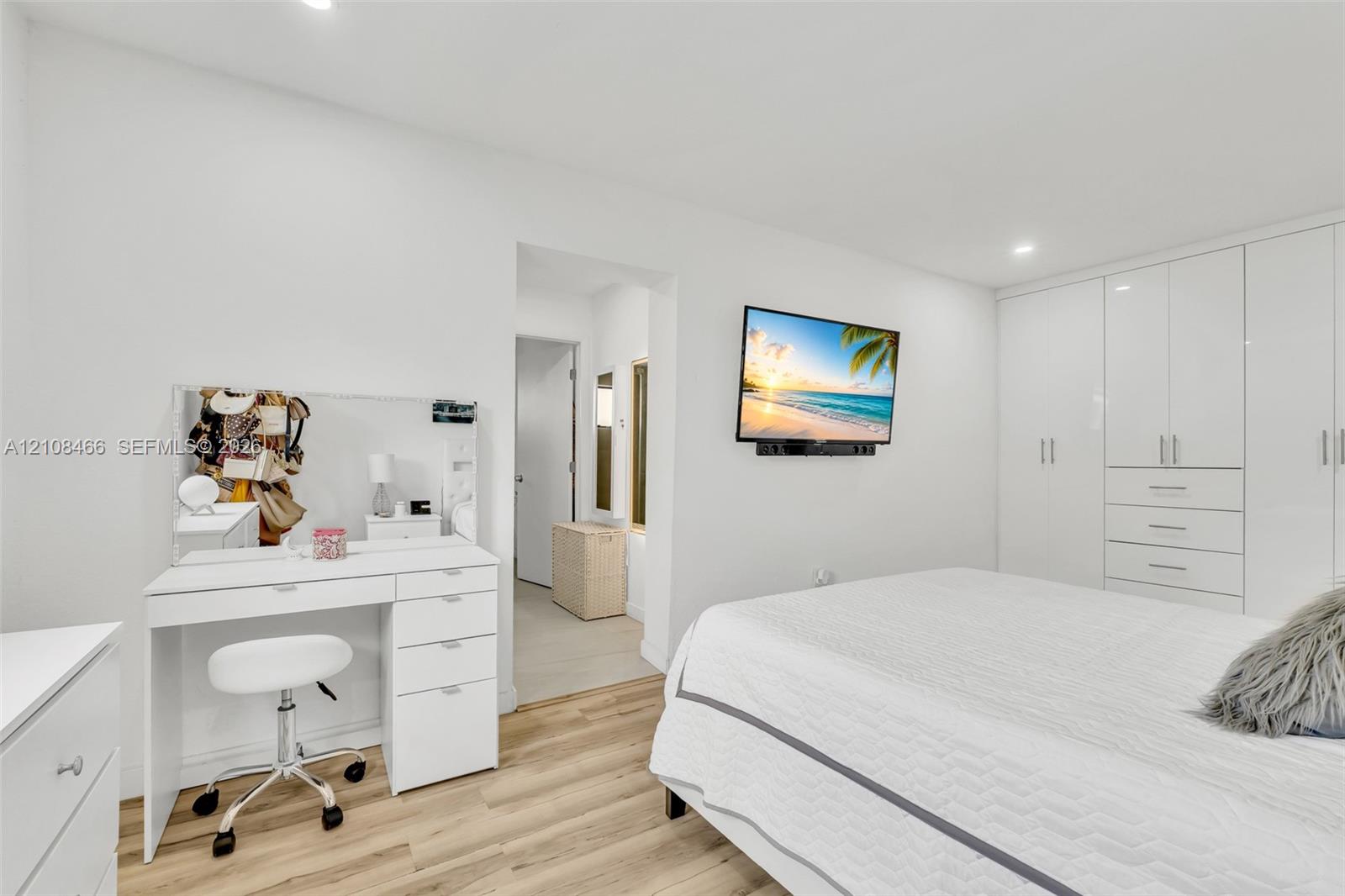 Interior space featuring wood-finish flooring, recessed lighting, and expansive floor-to-ceiling built-in cabinetry with integrated drawers