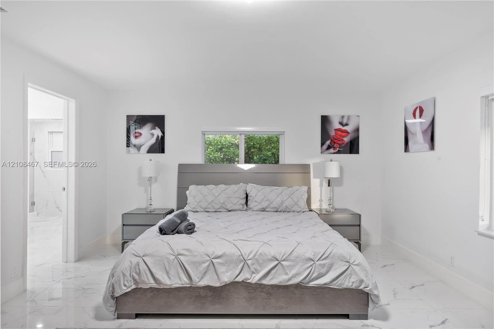 Interior space featuring high-gloss, large-format tile flooring with marble-pattern veining and a centered window