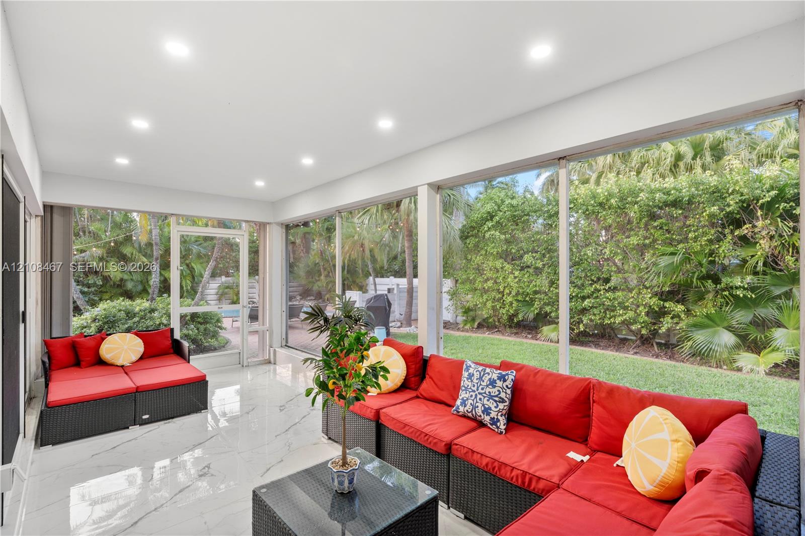 Enclosed lanai featuring large-format stone-finish tile flooring, recessed ceiling lighting, and floor-to-ceiling screen paneling