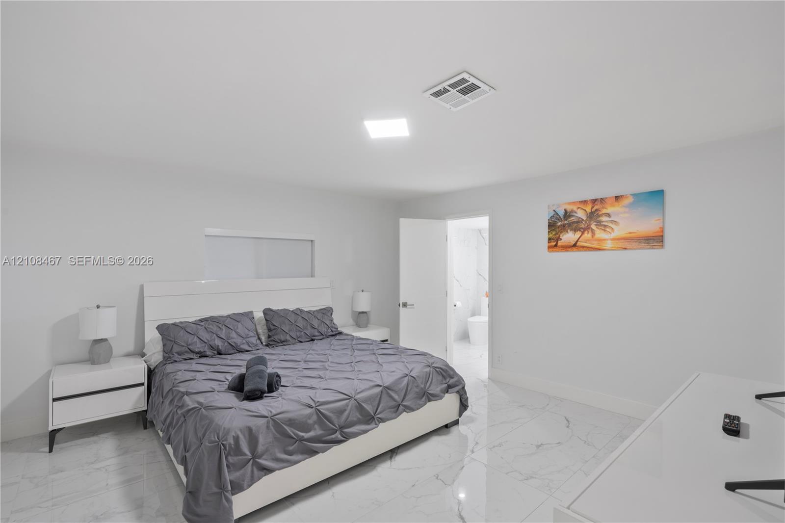Large-format tile flooring with a neutral-toned veined finish, recessed lighting, and crisp white wall surfaces