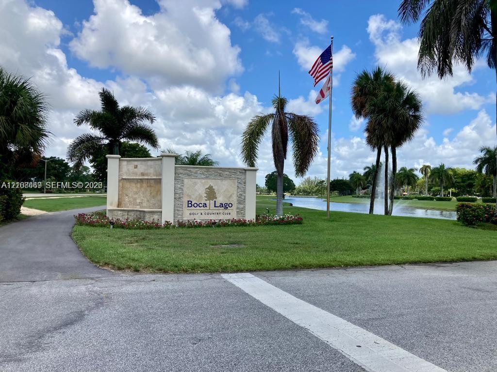Stone-clad monument signage, manicured landscaping, mature palm trees