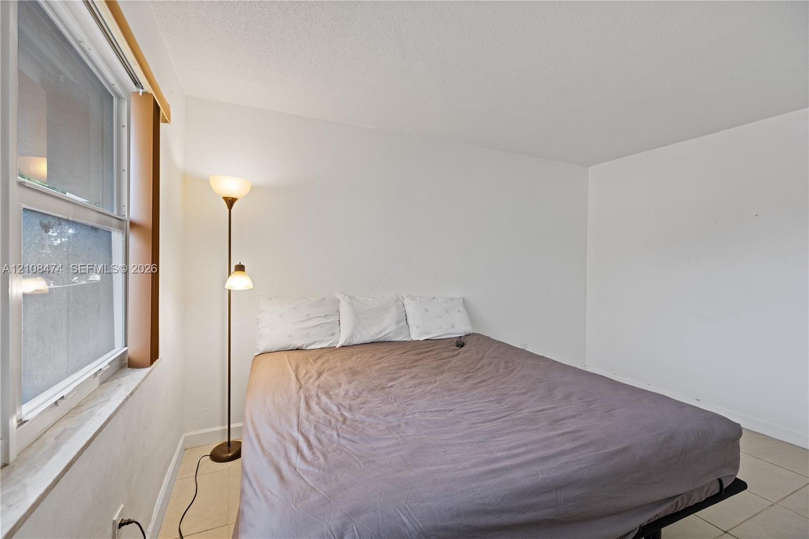 Neutral-toned tile flooring and single-hung window with a deep sill