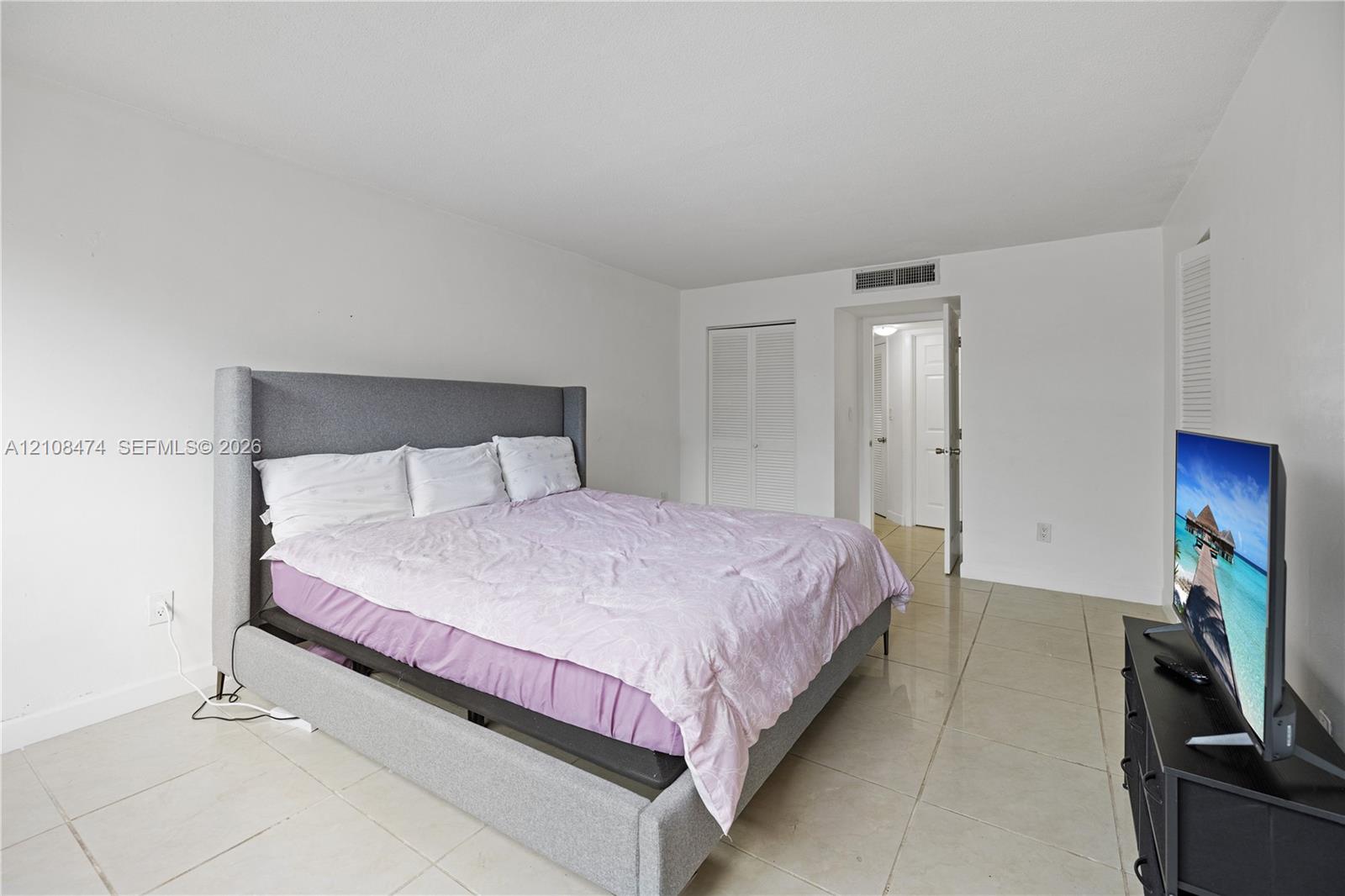 Neutral-toned tile flooring, white wall finishes, and bi-fold closet doors