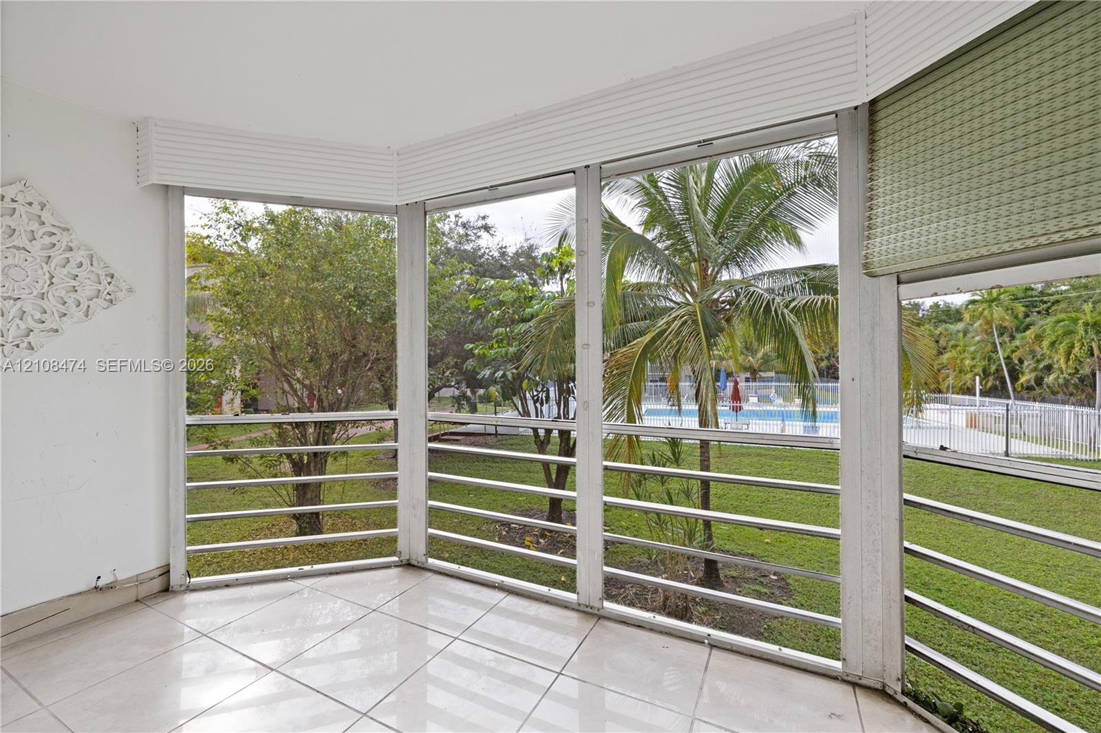 Enclosed porch featuring tile flooring, expansive floor-to-ceiling screen panels, and white framing
