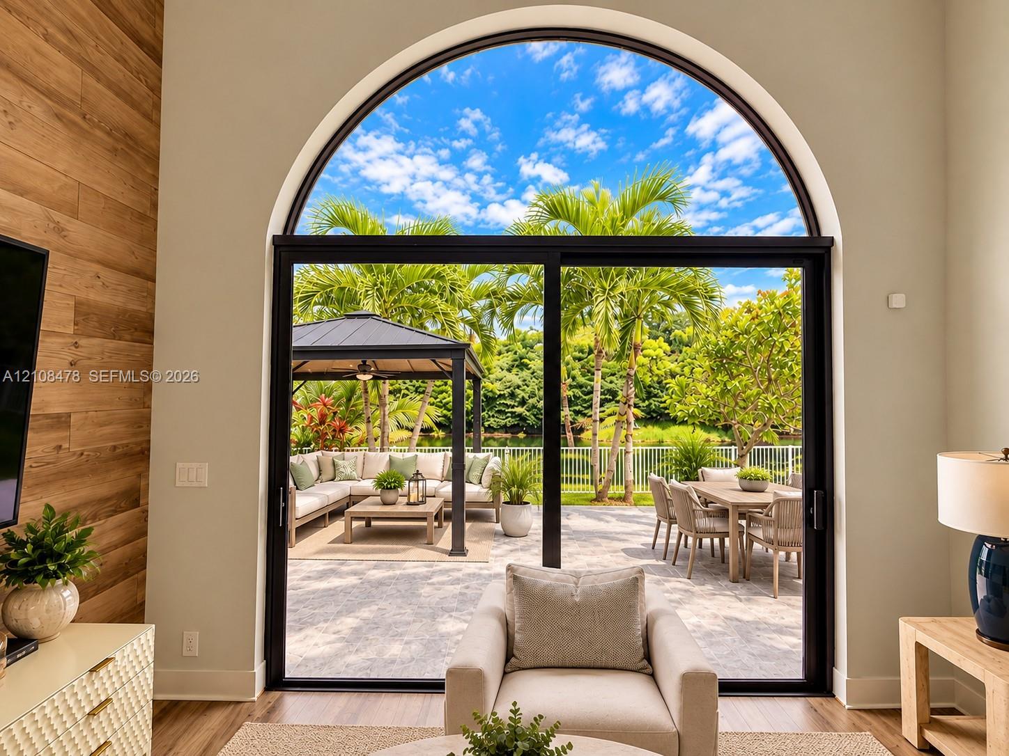 Stucco exterior featuring an arched entryway, double-door entrance, stone-paver driveway, and gabled roofline