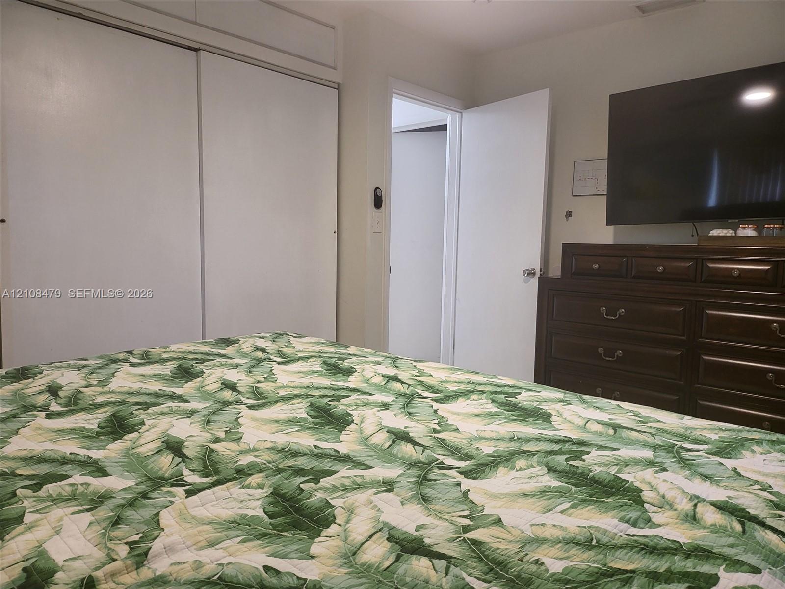 Room featuring floor-to-ceiling sliding-door closet storage with overhead cabinetry and a standard interior door