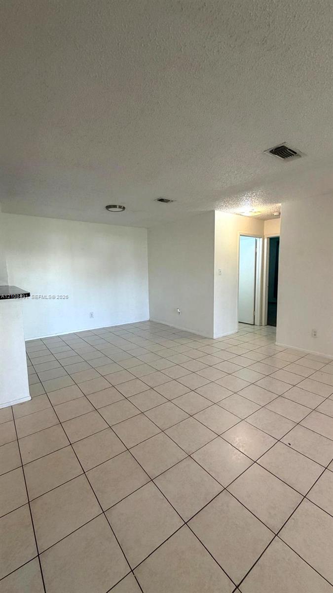 Open floor plan featuring light-colored tile flooring, neutral wall tones, and recessed lighting fixtures Open floor plan featuring light-colored tile flooring, neutral wall tones, and recessed lighting fixtures