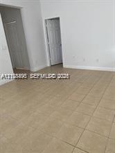 Interior space featuring neutral wall paint, large-format ceramic tile flooring, and multi-panel interior doors