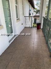 Covered balcony featuring tile flooring and decorative metal railings