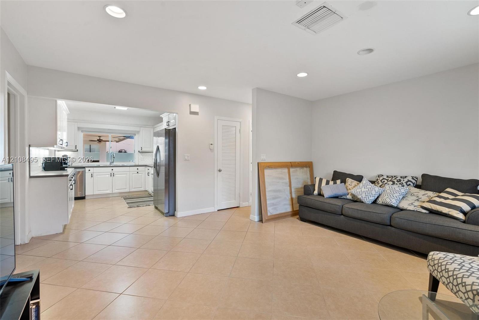 Open-concept area featuring neutral wall tones, recessed lighting, and tile flooring throughout