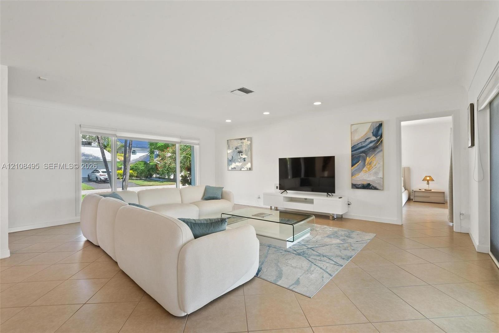 Open-concept interior featuring oversized tile flooring, recessed ceiling lighting, and large sliding glass windows
