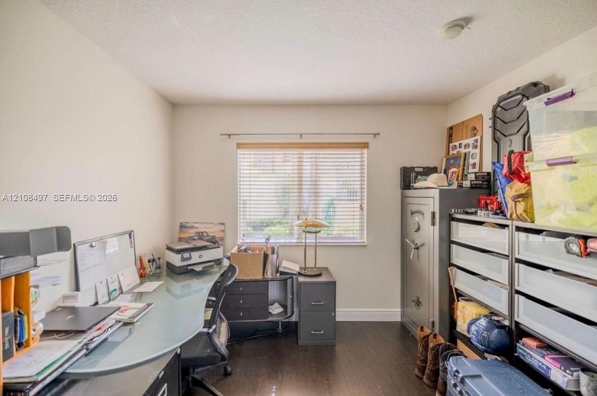 Room featuring wood-finish flooring, neutral wall paint, and a window with horizontal blinds