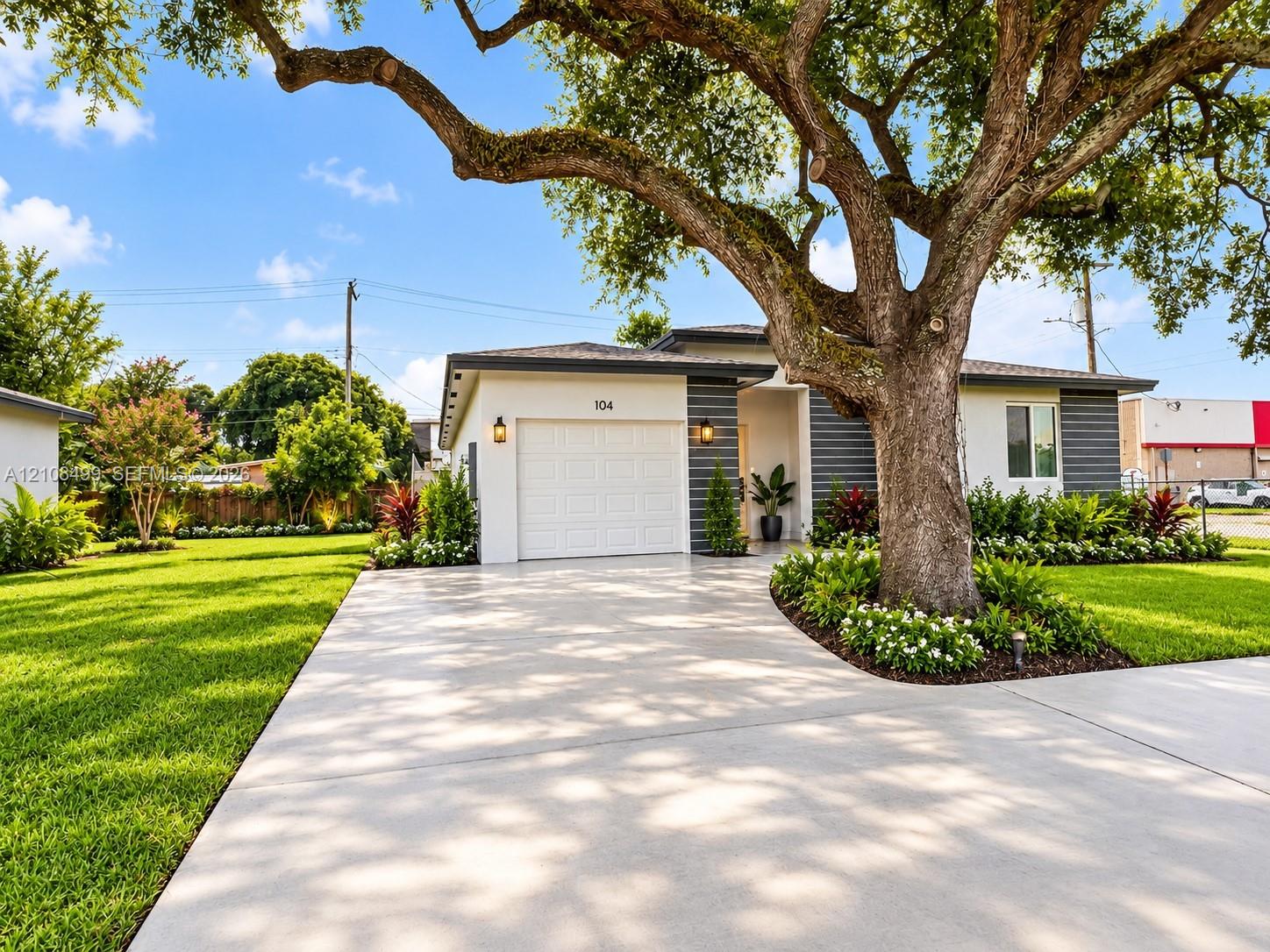 Exterior featuring a concrete driveway, attached garage, mature landscaping, and horizontal siding accents
