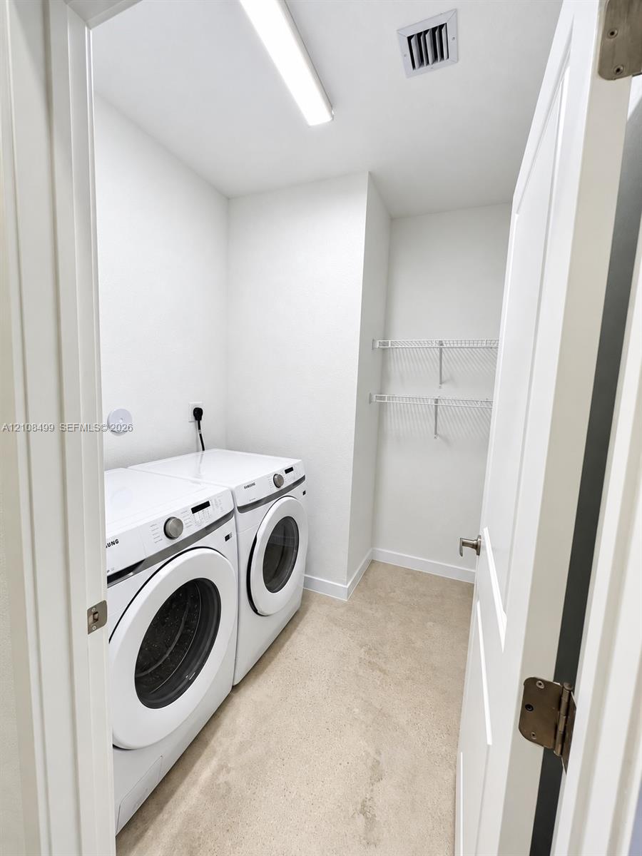 Utility space featuring neutral carpeting, white walls, overhead LED lighting, and dual wall-mounted wire storage shelves