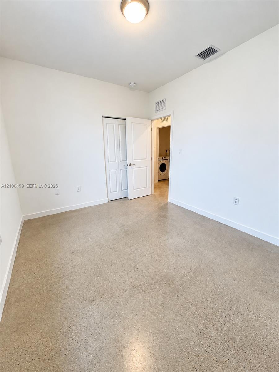 Polished concrete flooring, recessed ceiling lighting, and a multi-panel interior door