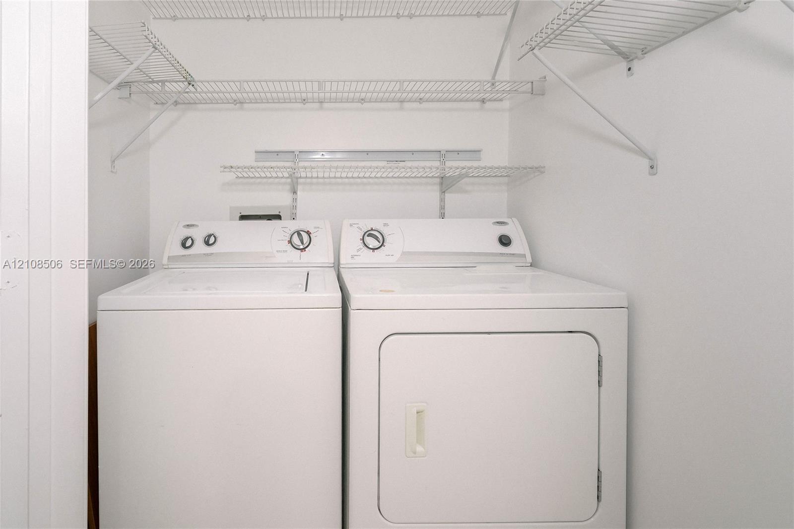 Laundry area featuring multi-level wire shelving and side-by-side appliances