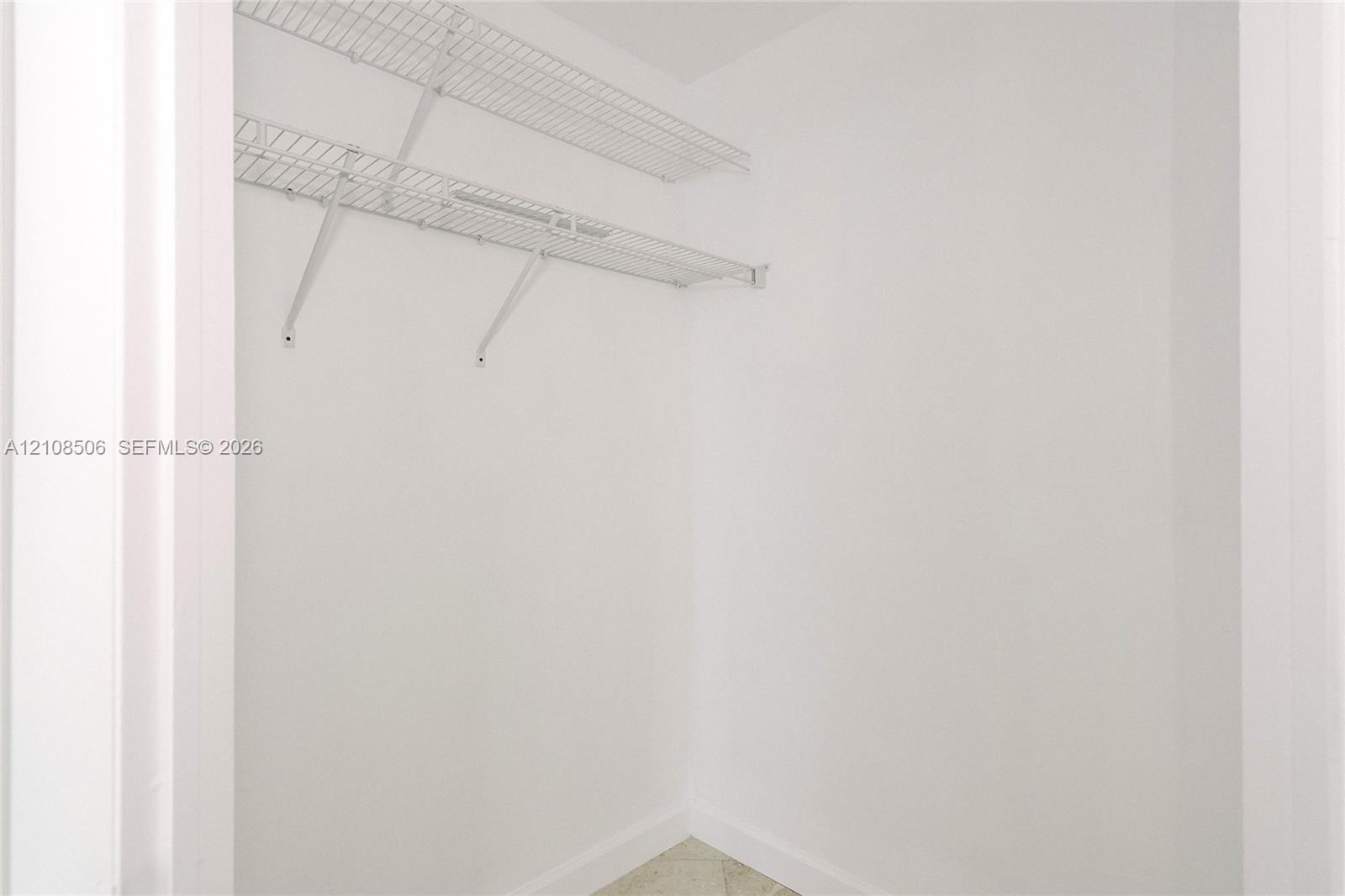 Storage area featuring dual-tiered white wire shelving