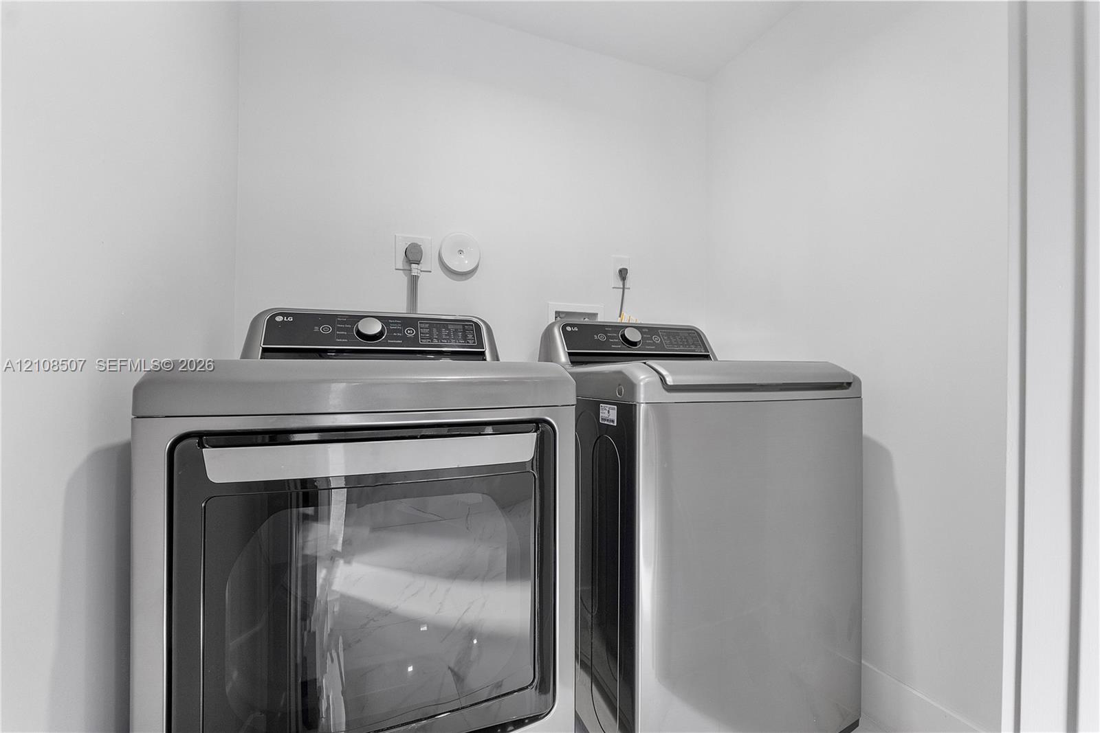 Dedicated laundry alcove equipped with stainless steel front-loading washer and dryer units