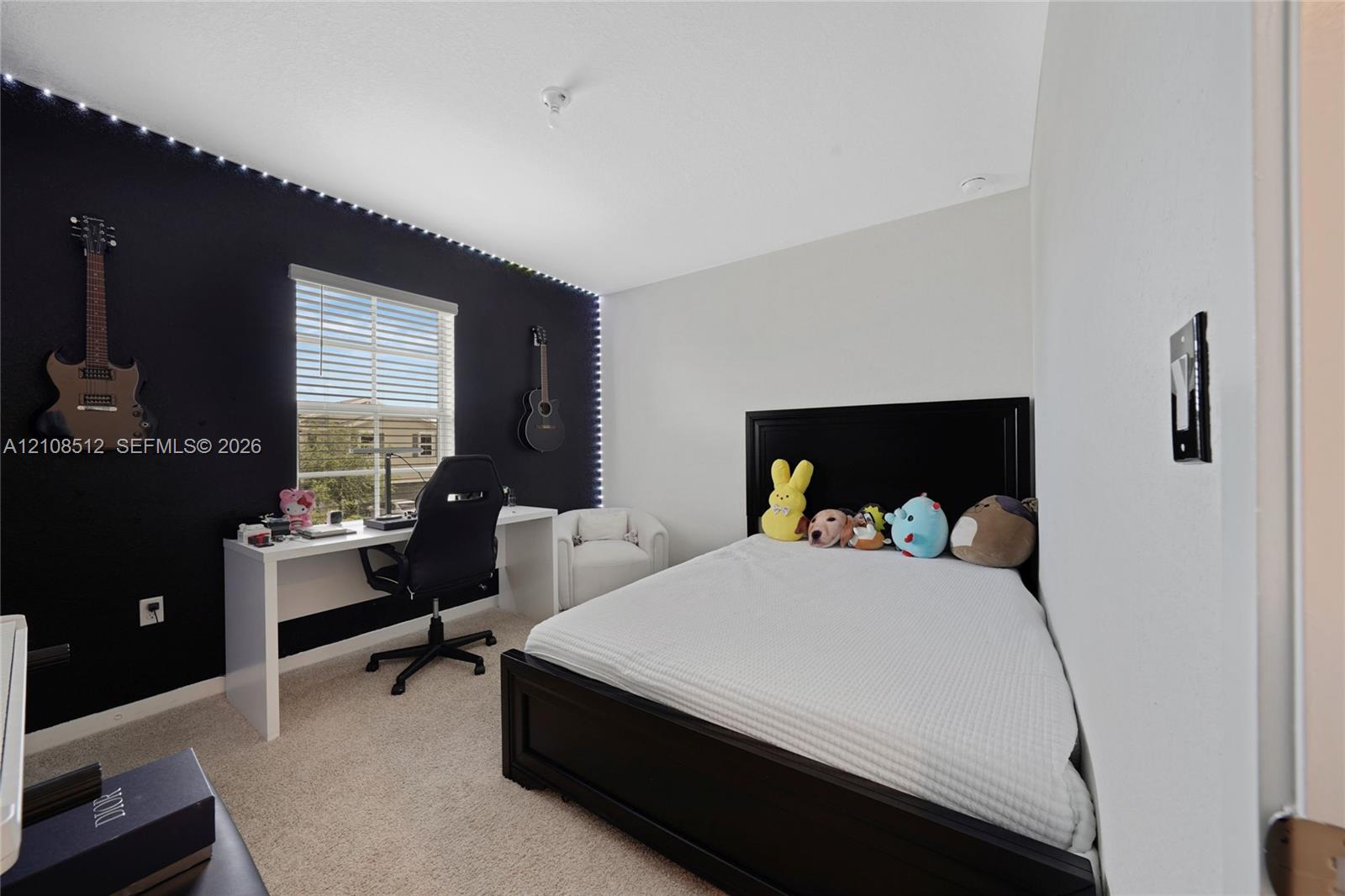 Bedroom featuring a neutral carpet, dual-tone walls, integrated perimeter ceiling lighting, and a single-pane window with blinds Bedroom featuring a neutral carpet, dual-tone walls, integrated perimeter ceiling lighting, and a single-pane window with blinds