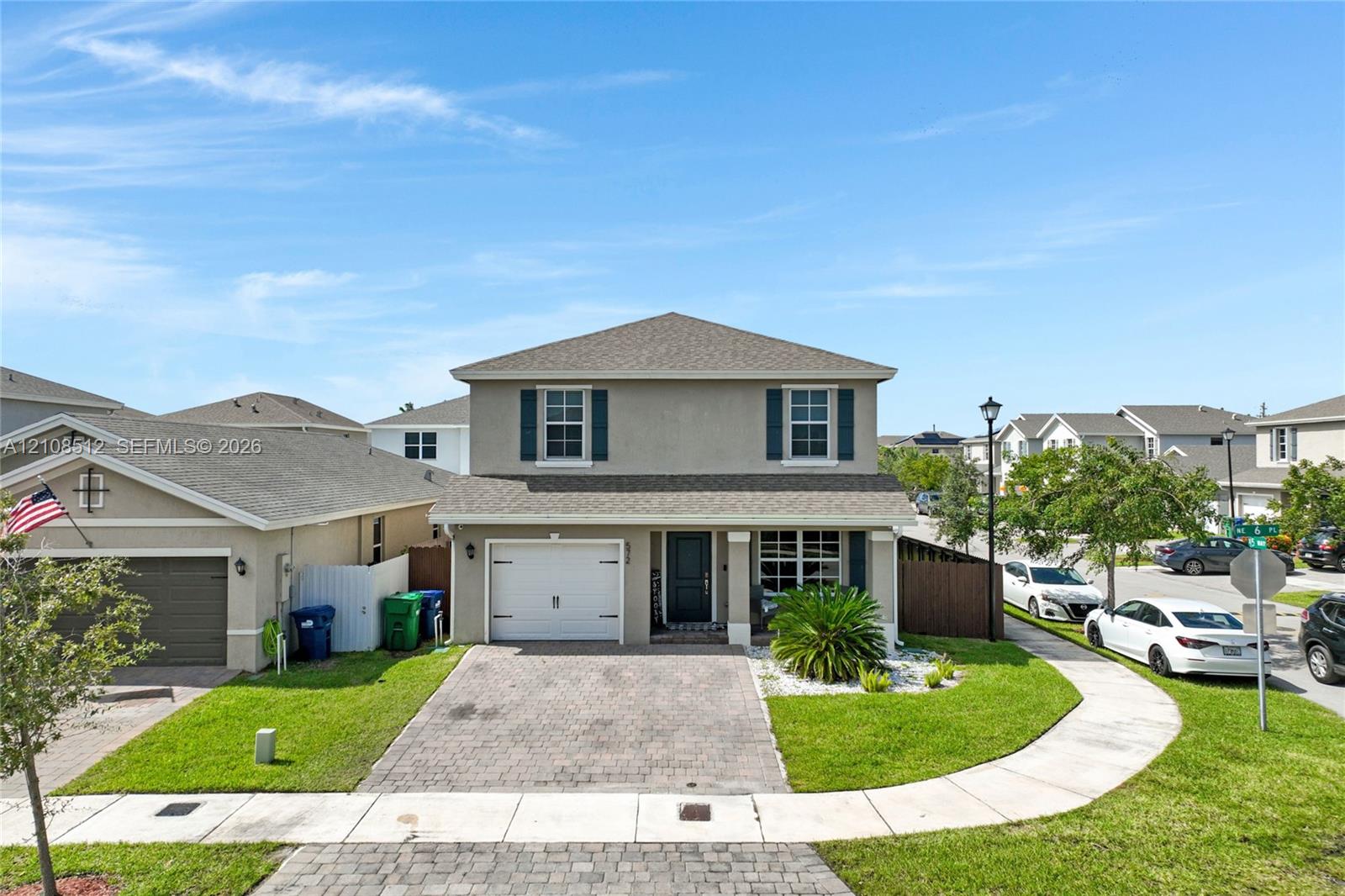 Two-story exterior featuring a stucco facade, paver driveway, single-car garage, and shuttered windows Two-story exterior featuring a stucco facade, paver driveway, single-car garage, and shuttered windows