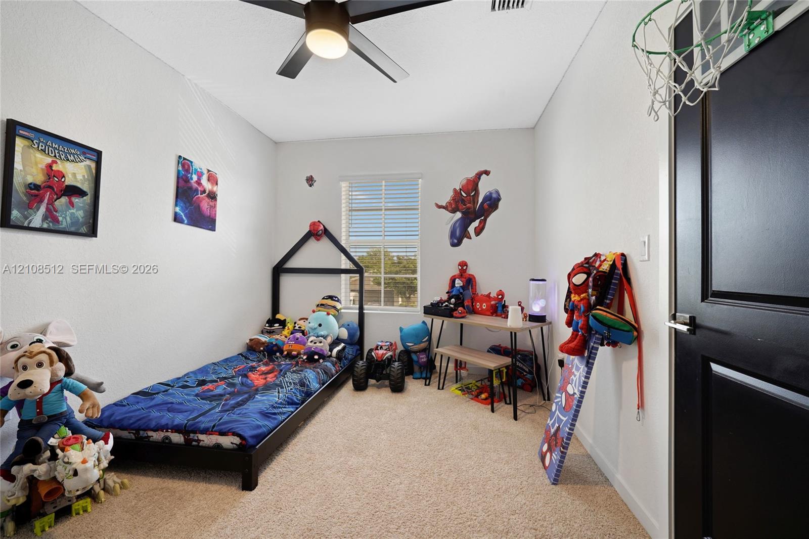 Neutral wall finish, carpeted flooring, window with blinds, ceiling fan with integrated light fixture, and door with contrasting trim Neutral wall finish, carpeted flooring, window with blinds, ceiling fan with integrated light fixture, and door with contrasting trim