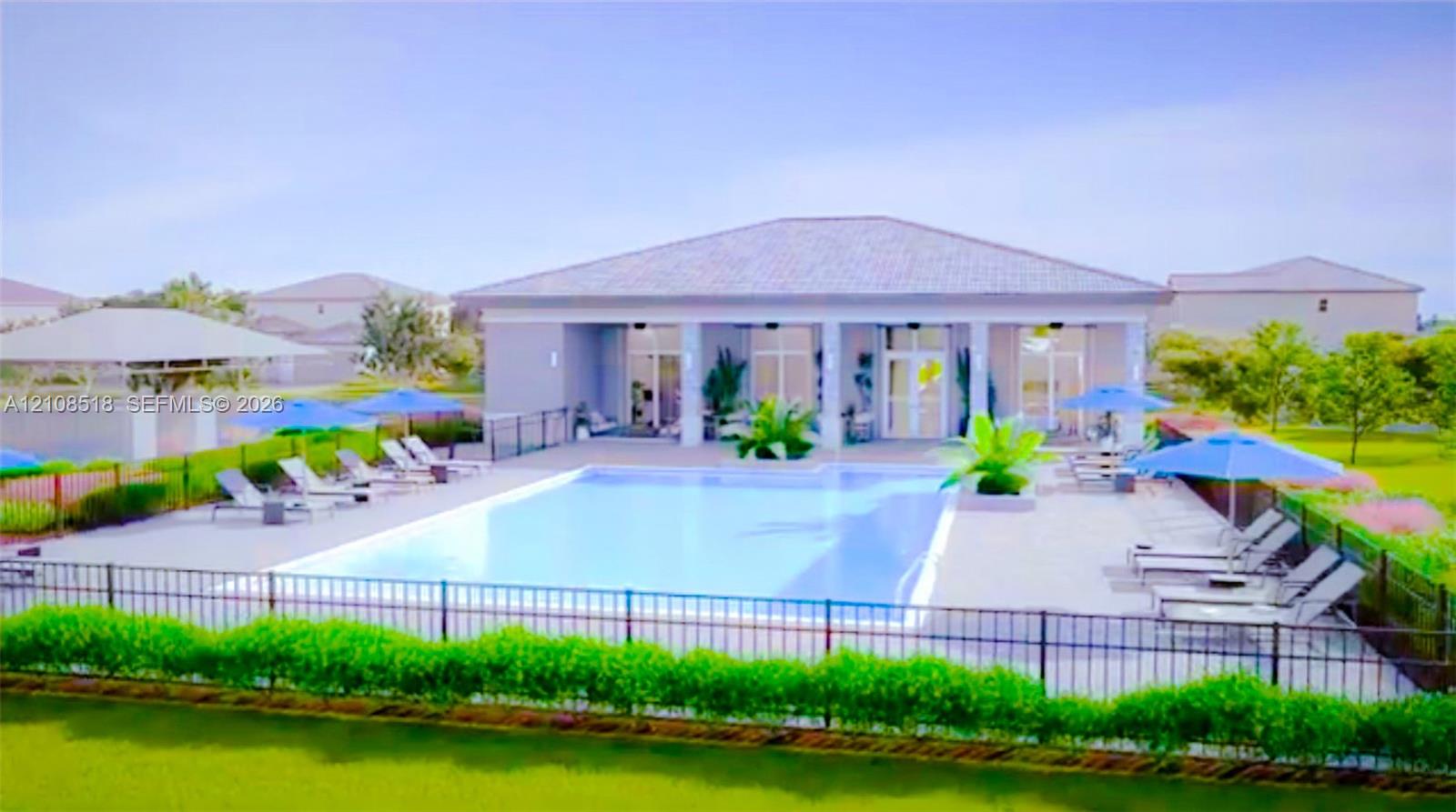 Rectangular swimming pool featuring a concrete deck, covered patio with structural columns, metal perimeter fencing, and manicured shrubbery
