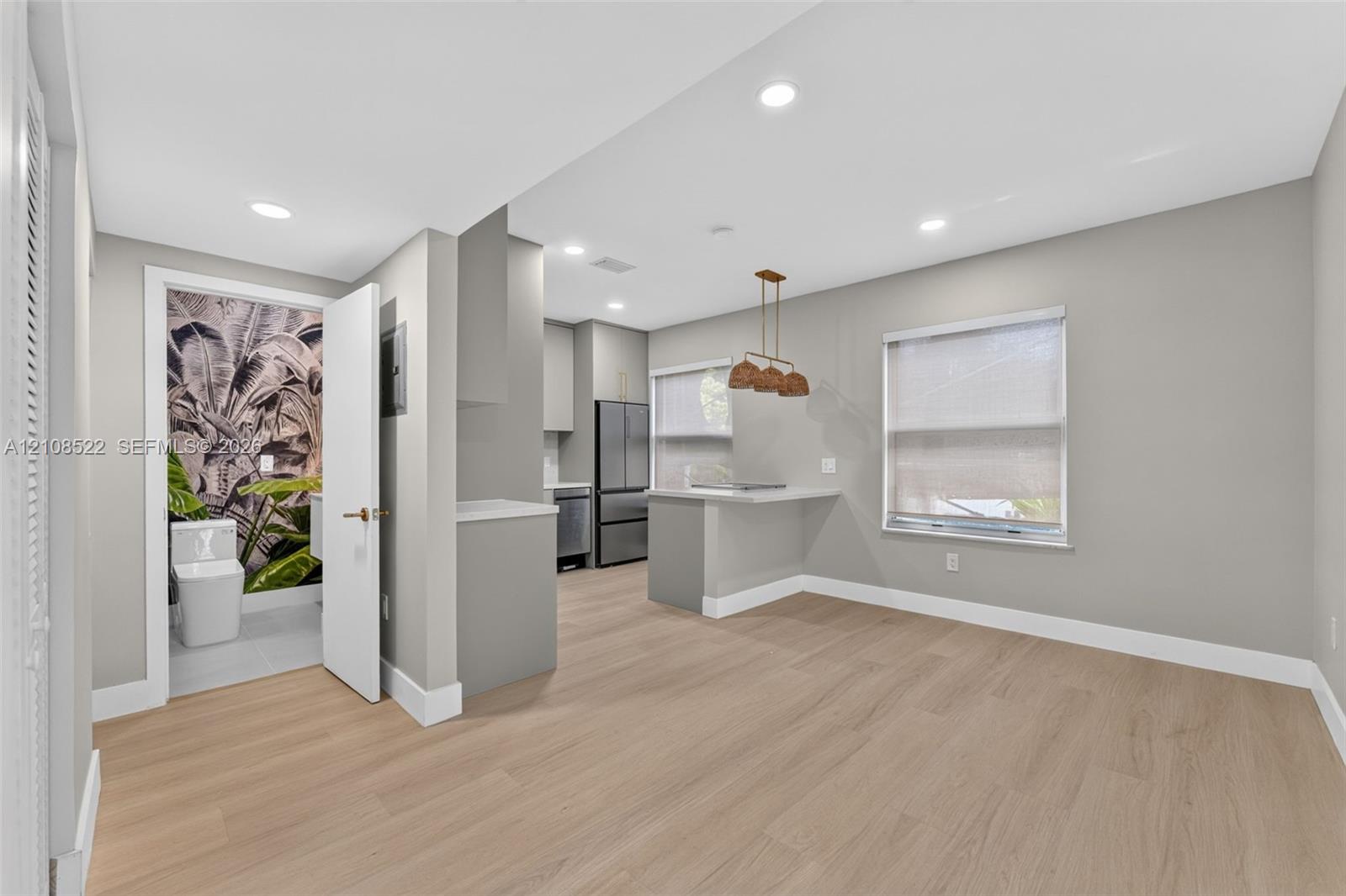 Kitchen featuring wood-finish flooring, recessed lighting, a breakfast bar, and stainless steel appliances