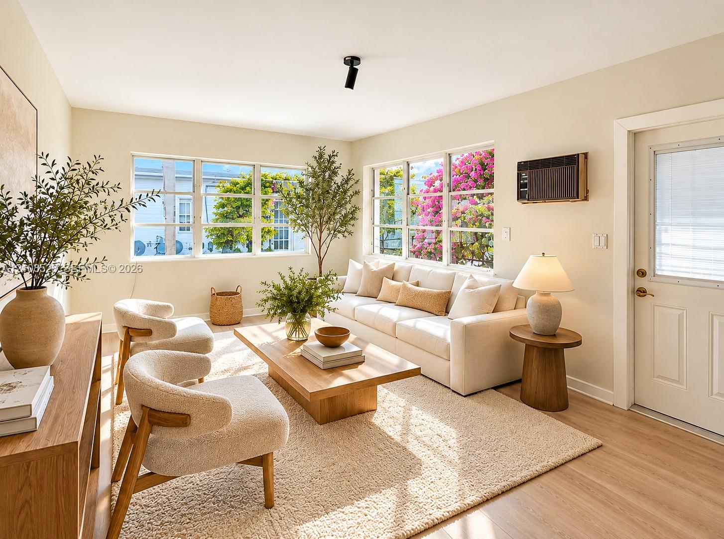 Living area featuring large paneled windows, wood-finish flooring, and a single black ceiling-mounted spotlight
