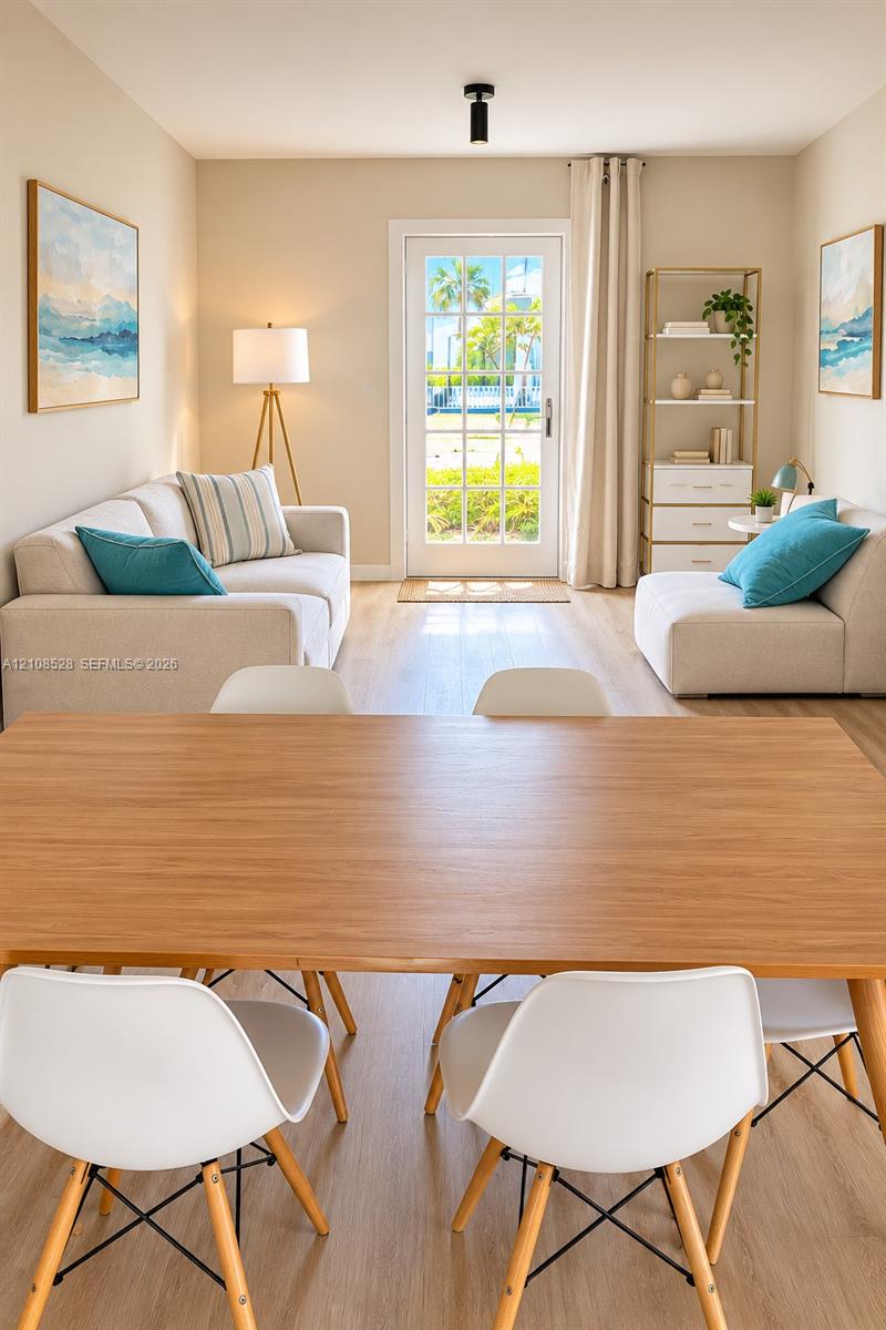 Light-filled room featuring wood-finish flooring, a central single-light flush mount fixture, and a paneled glass exterior door