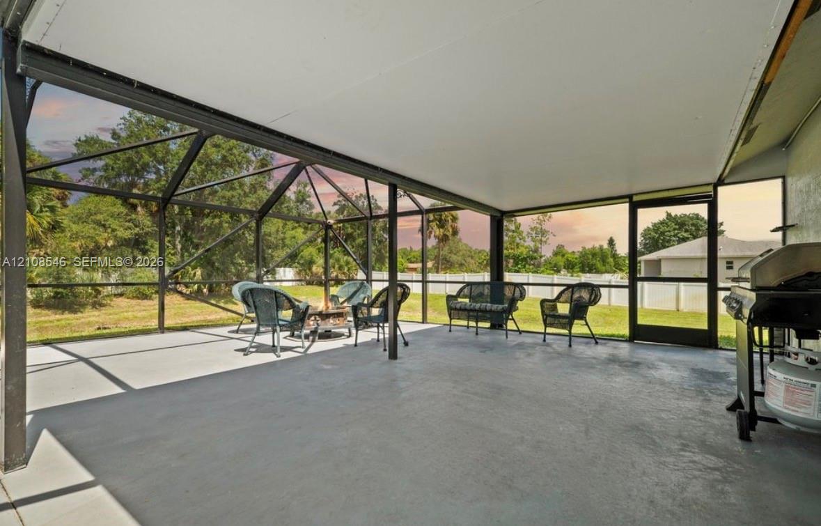 Screened lanai featuring a solid roof structure, concrete flooring, and metal framing Screened lanai featuring a solid roof structure, concrete flooring, and metal framing