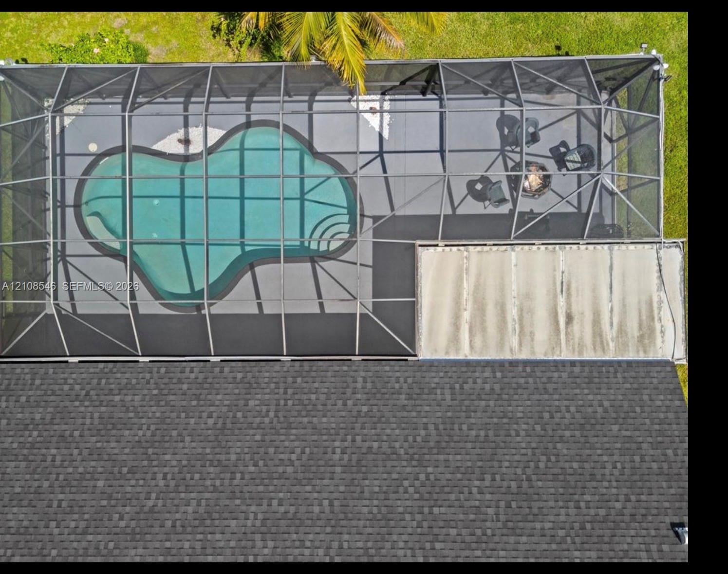 Pool enclosed by a screened lanai with concrete decking and a covered patio area